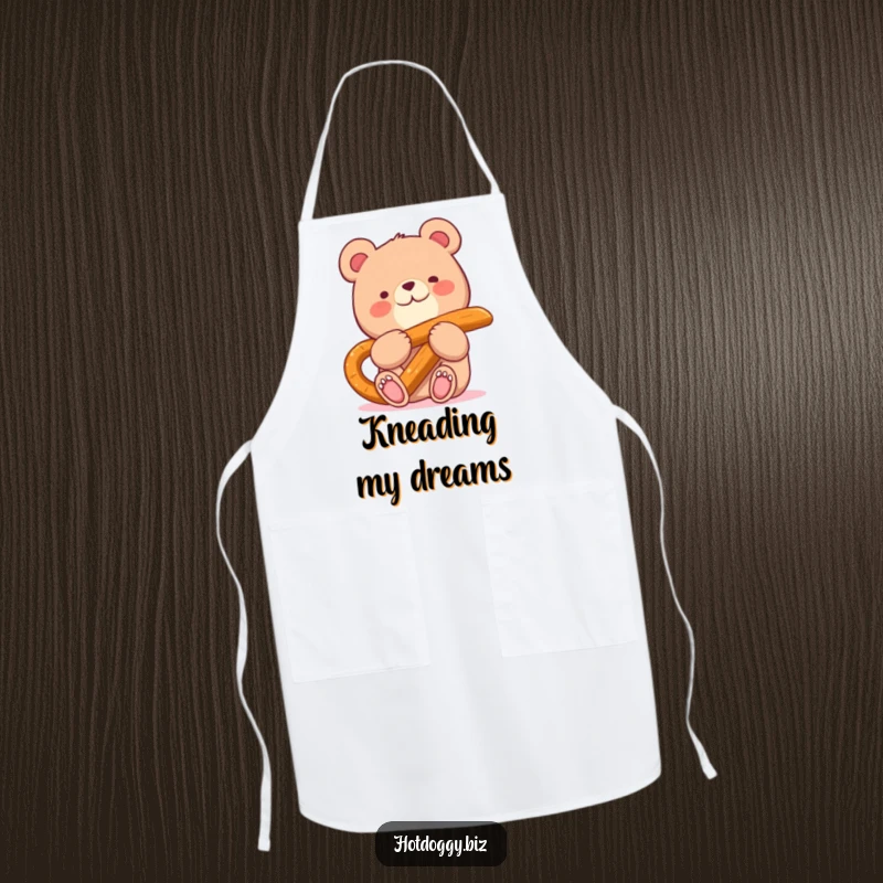 Funny apron featuring a happy bear character happily munching on a giant pretzel stick while in the kitchen.